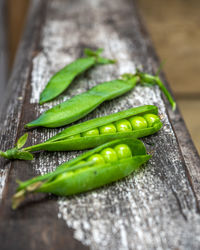Pods of young green peas on wooden railing of a country house