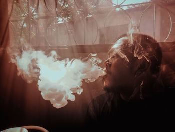 Digital composite image of man smoking cigarette