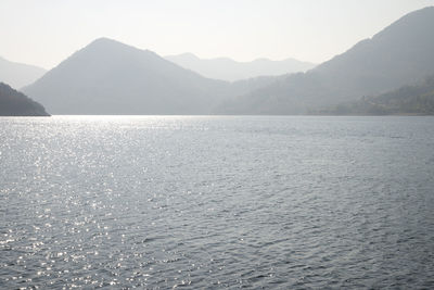 Scenic view of sea and mountains against clear sky