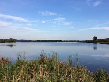 Scenic view of lake against cloudy sky