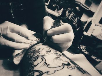 Artist making tattoo on hand at studio