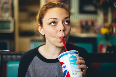 Portrait of young woman drinking coffee