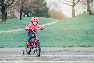 Portrait of girl riding bicycle on walkway