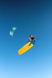 Kitesurfing, professional rider flying performing a trick, looking at the camera while hovering in