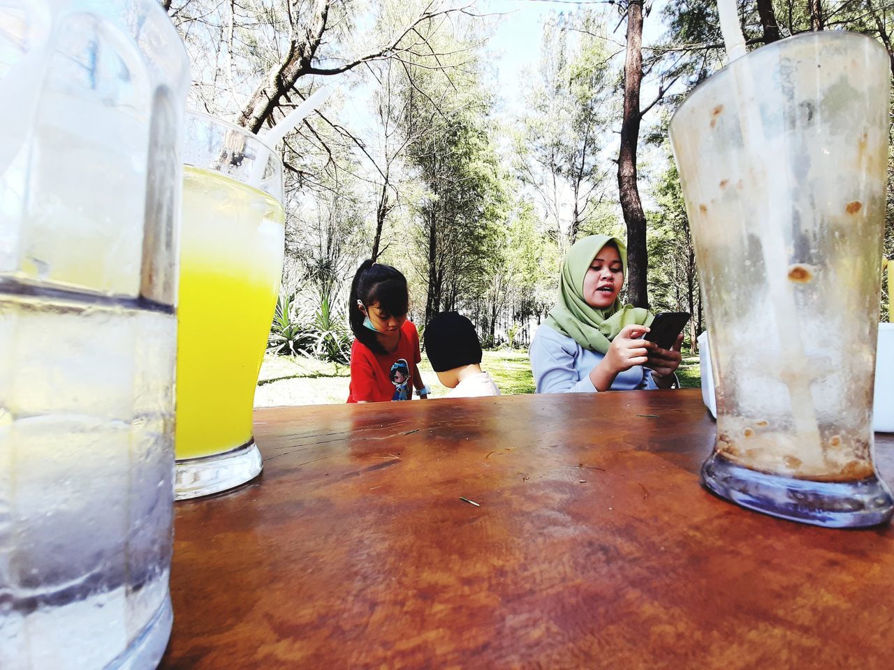 REAR VIEW OF PEOPLE SITTING ON TABLE