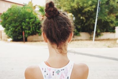 Rear view of young woman against trees