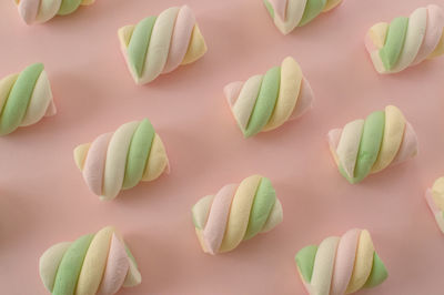 Colorful marshmallows composition on a pink background - copy space - children candies concept