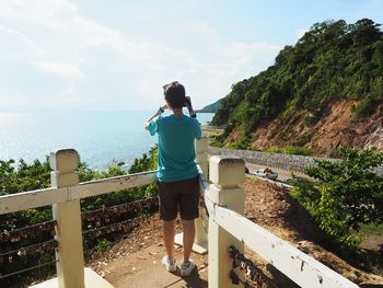 Rear view of woman looking at sea against sky