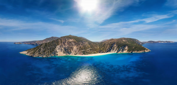 Panoramic view of sea and mountains against blue sky