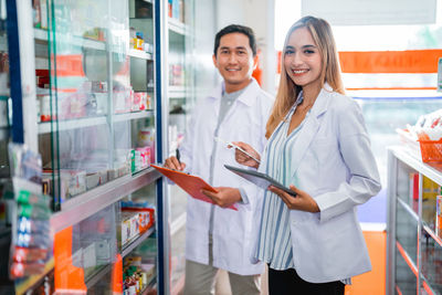 Portrait of smiling young woman standing in store