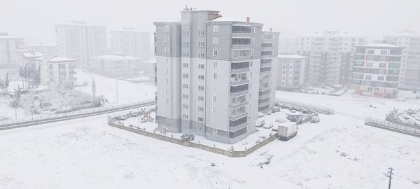 High angle view of snow covered buildings in city