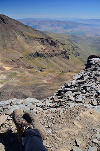 Low section of man relaxing on mountain 