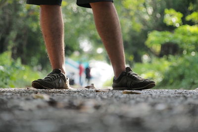 Low section of man standing on road