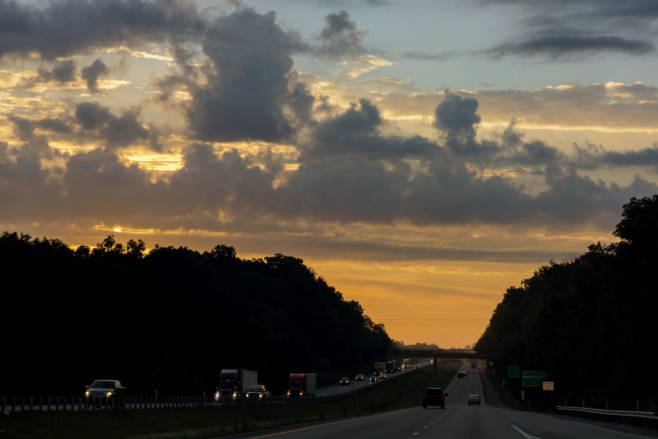 CARS ON STREET AGAINST SKY DURING SUNSET