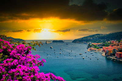 Scenic view of sea against cloudy sky during sunset