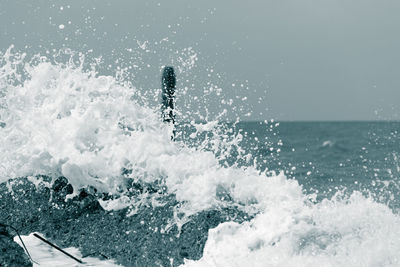 Water splashing in sea against sky