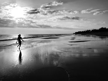 Silhouette man on beach against sky