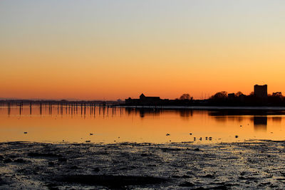 Scenic view of lake against orange sky