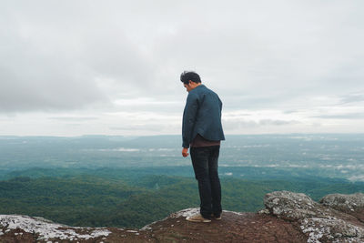 Full length of man standing by cliff against sky