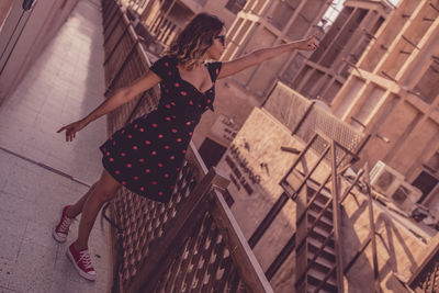 Front view of young woman in balcony by railing