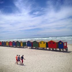 People at beach against sky