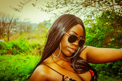 Portrait of woman wearing sunglasses on field