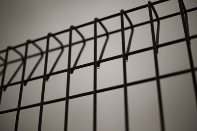 Close-up of metal fence against clear sky
