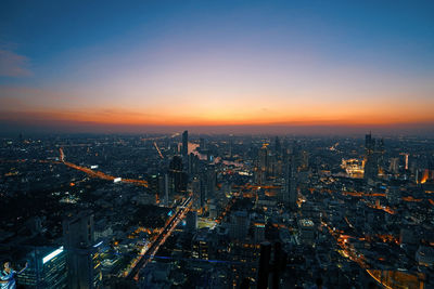 High angle view of illuminated buildings against sky at sunset