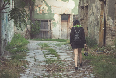 Rear view of woman walking in alleyway