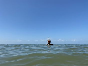 Portrait of man swimming in sea against clear sky