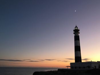 Low angle view of lighthouse against sky during sunset