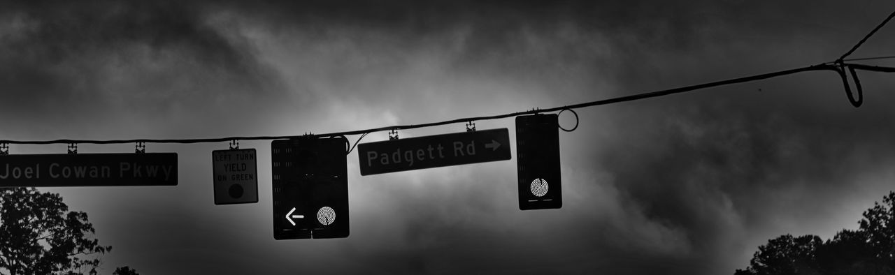 text, communication, western script, low angle view, sky, information sign, information, sign, non-western script, capital letter, guidance, illuminated, cloud - sky, road sign, directional sign, cloudy, no people, outdoors, arrow symbol, dusk