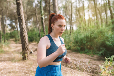 Determined woman running in forest