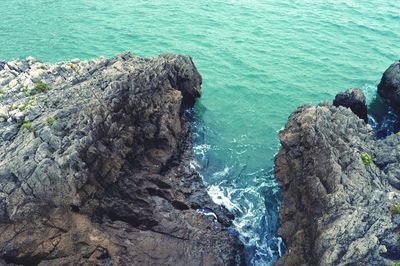 High angle view of rock formation in sea against sky