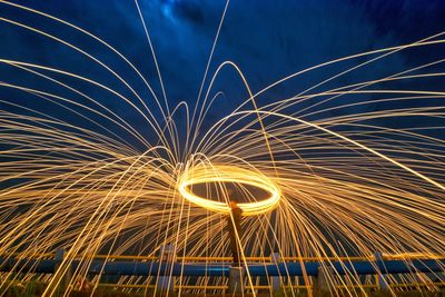 Man standing amidst wire wool at night