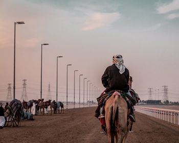 People riding horse cart against sky