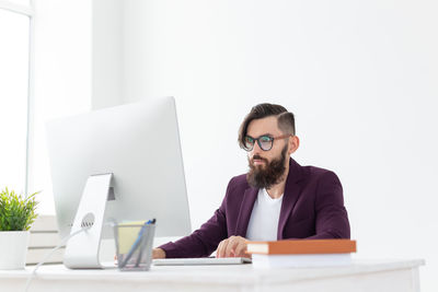 Young man using smart phone while sitting on table