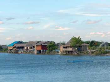 Houses by sea against sky