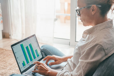 Side view of man using laptop at office