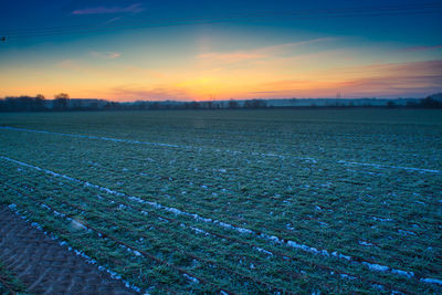 Scenic view of field against sky during sunset