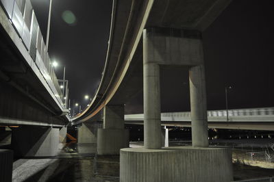 Rear view of man standing on bridge at night