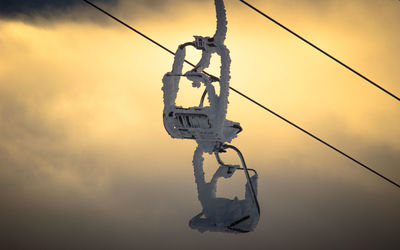 Low angle view of telephone pole against sky during sunset