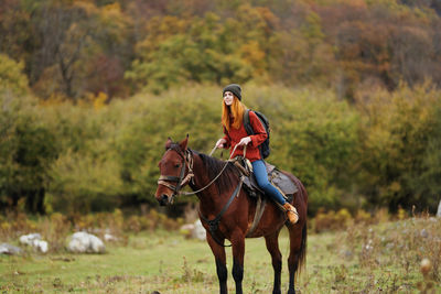 Close-up of horse riding on field