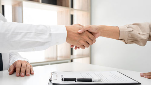 Midsection of businessman giving handshake