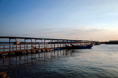 Pier over sea against sky during sunset