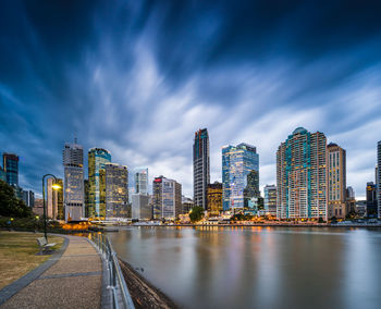 Illuminated buildings by city against sky