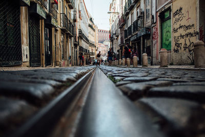 Surface level of railroad track on street amidst buildings in city