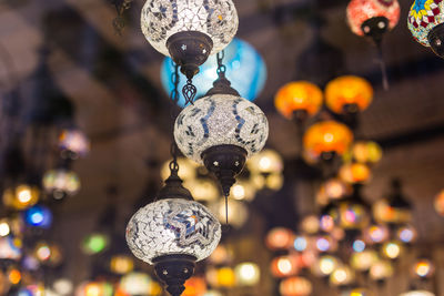 Low angle view of illuminated lighting equipment hanging at market