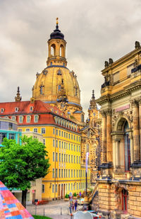 Buildings in city against cloudy sky