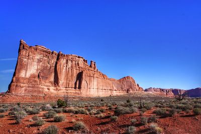 Rock formations on landscape against blue sky